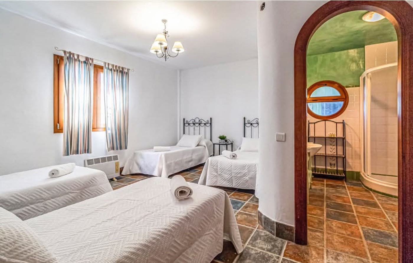 Habitación con tres camas individuales y baño en suite
